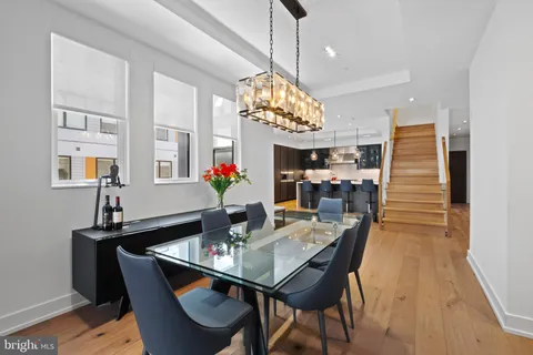 a dining room with furniture a chandelier and wooden floor