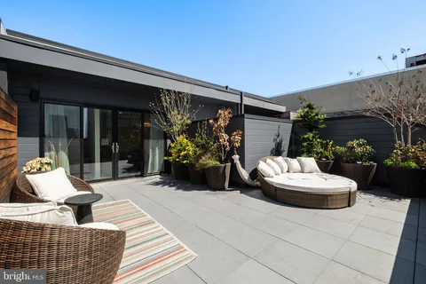 a view of a patio with couple of chairs and potted plants