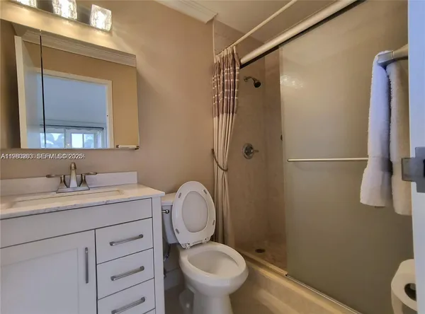 a bathroom with a granite countertop toilet and a sink