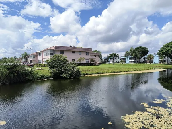 a view of a lake with table and chairs under an umbrella