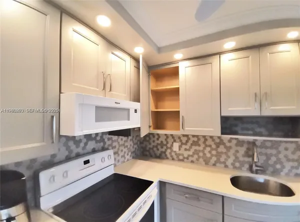 a kitchen with a sink and a stove top oven