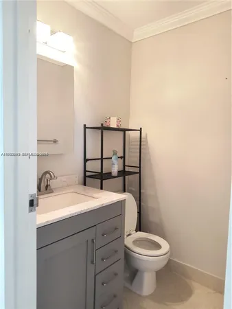 a bathroom with a granite countertop toilet sink and mirror