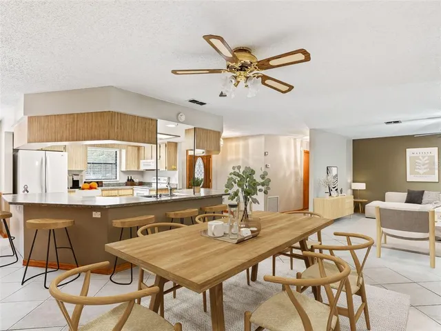 a dining room with stainless steel appliances a table and chairs with wooden floor