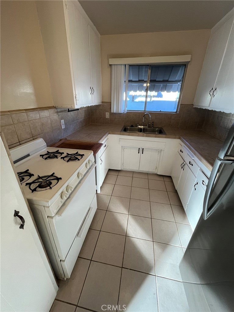 14632 Erwin Street, Unit 7 Van Nuys, CA 91411 - Photo 5 of 11 a kitchen with a stove a sink and a refrigerator