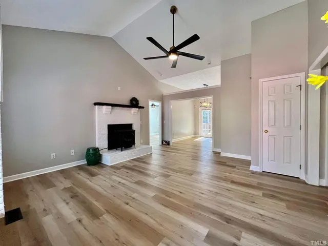 a view of empty room with wooden floor and ceiling fan
