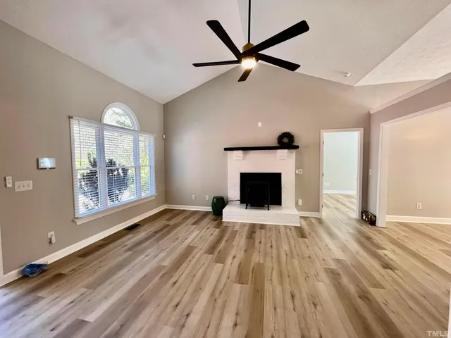 wooden floor fireplace and windows in an empty room