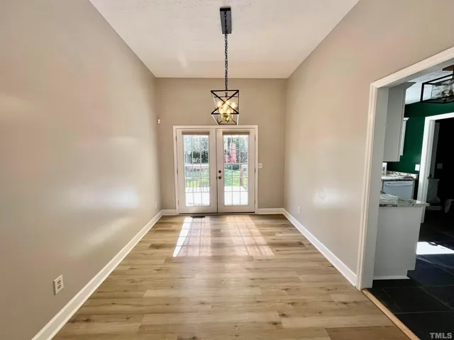 a view of a room with window wooden floor and front door