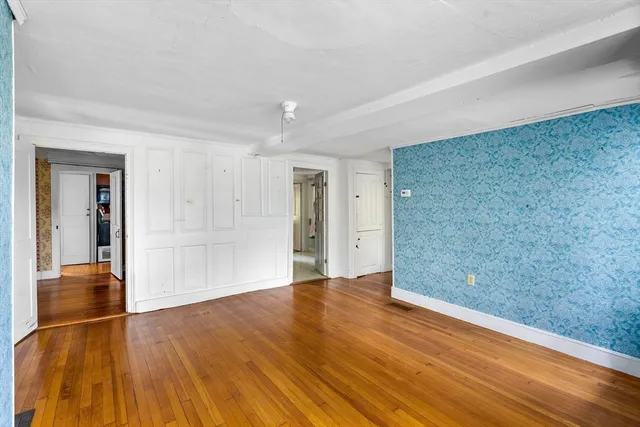 a view of an empty room with wooden floor