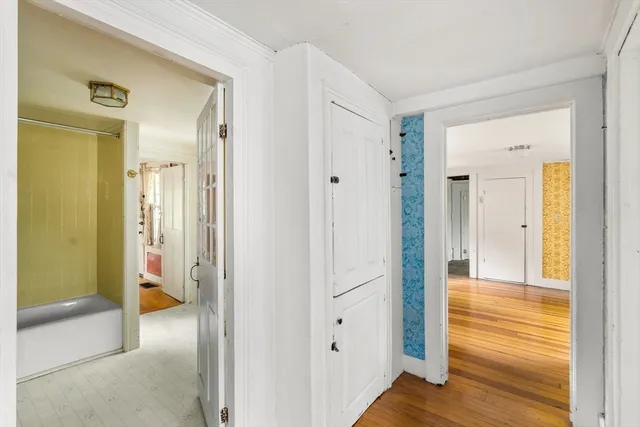 a view of a hallway with wooden floor and closet