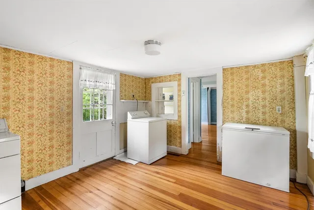 a view of a room with wooden floor and a refrigerator