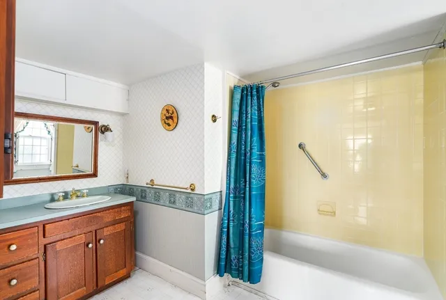 a spacious bathroom with a granite countertop sink mirror and a bathtub