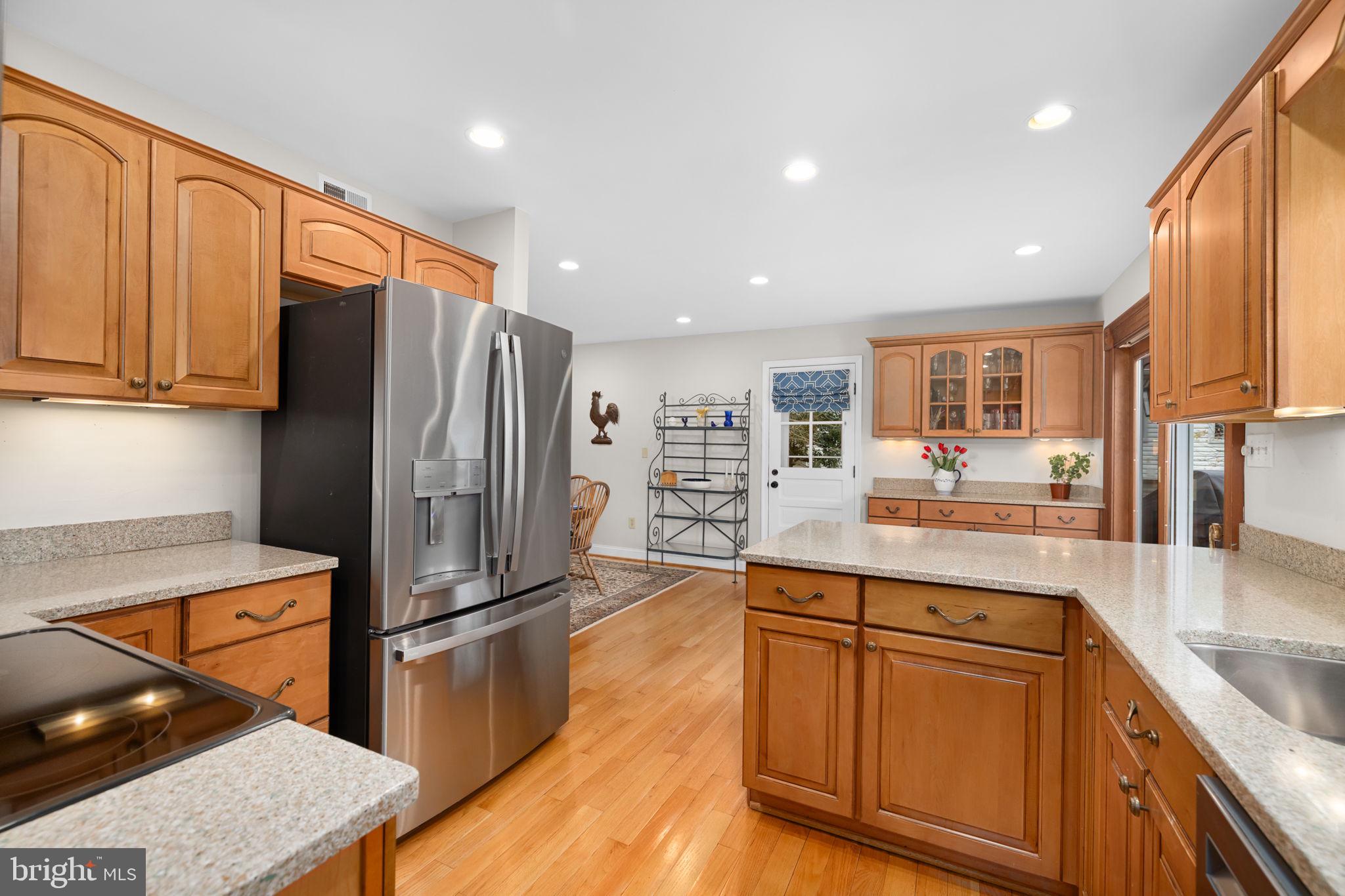 6964 Conservation Drive Springfield, VA 22153 - Photo 15 of 57 a kitchen with stainless steel appliances granite countertop a refrigerator and a stove top oven
