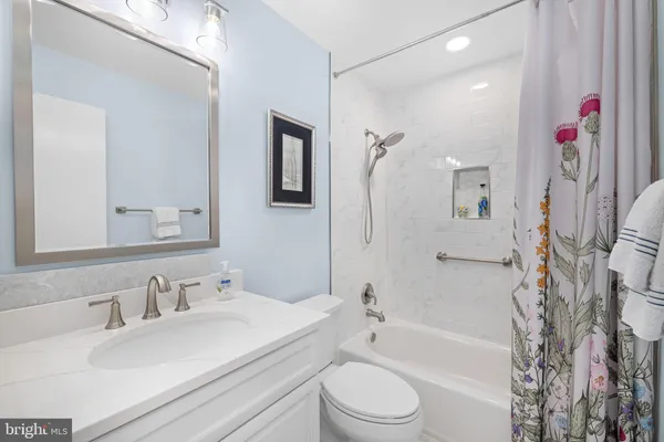 a bathroom with a granite countertop sink a mirror a shower and a mirror