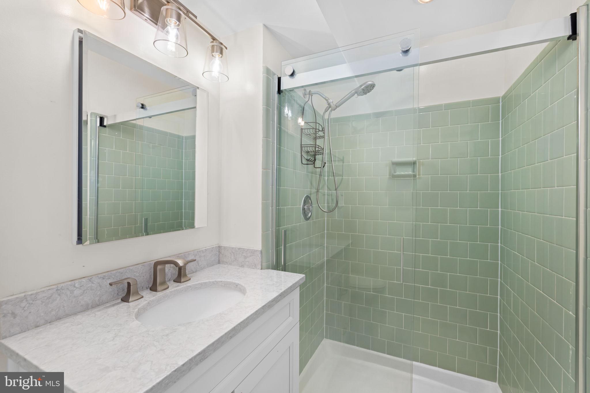 6964 Conservation Drive Springfield, VA 22153 - Photo 35 of 57 a bathroom with a granite countertop sink a mirror a shower and a mirror