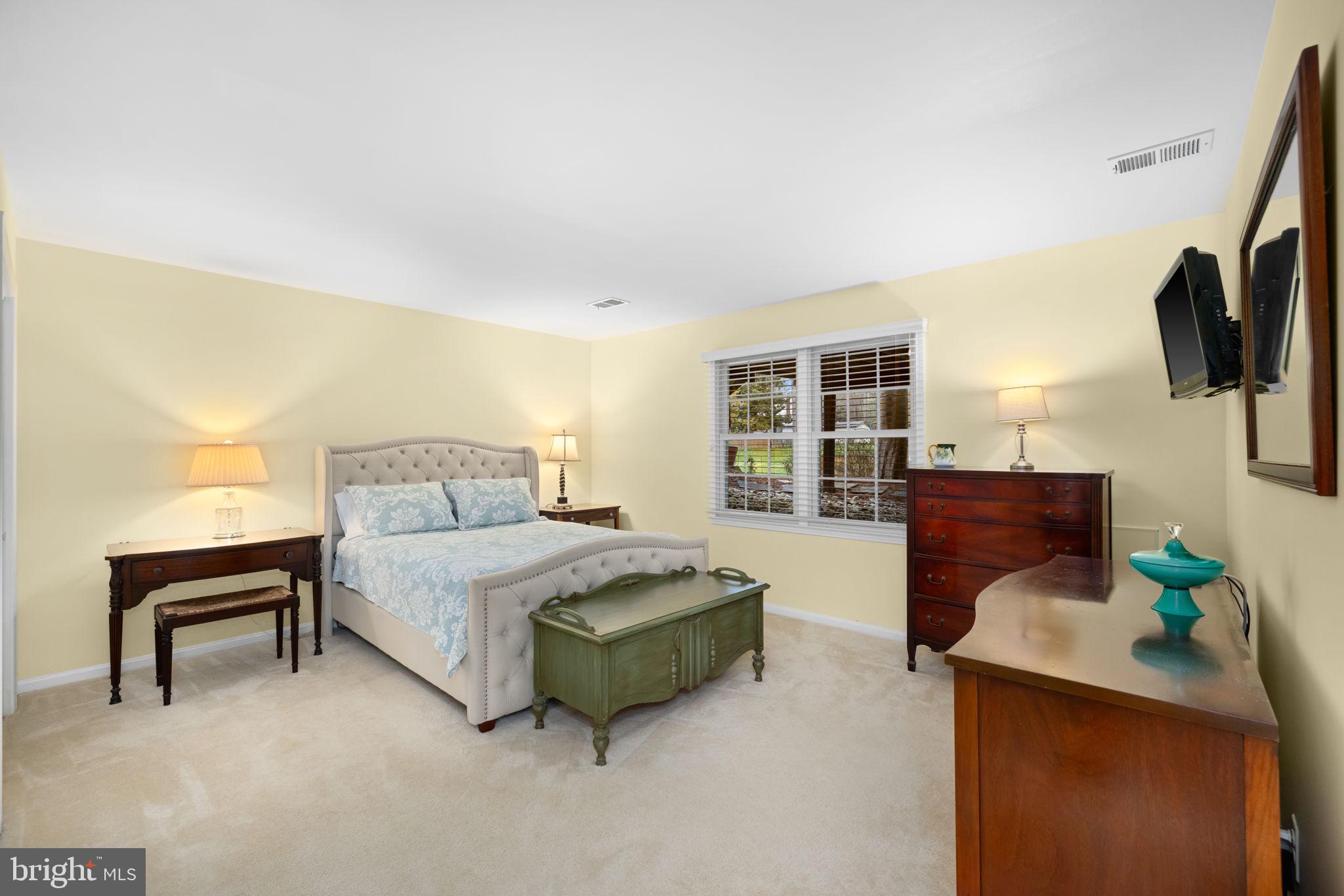 6964 Conservation Drive Springfield, VA 22153 - Photo 36 of 57 a spacious bedroom with a bed and flat screen tv