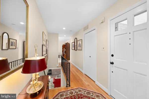 a kitchen with stainless steel appliances granite countertop a refrigerator a sink dishwasher a stove and white cabinets with wooden floor