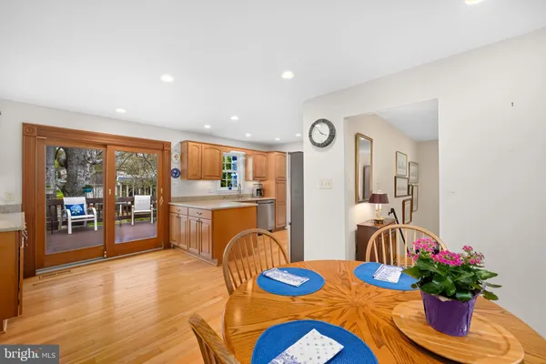 a kitchen with stainless steel appliances granite countertop a stove top oven a sink and a refrigerator with wooden floor