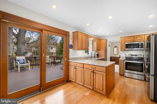 a kitchen with stainless steel appliances granite countertop a stove a sink and a refrigerator with wooden floor