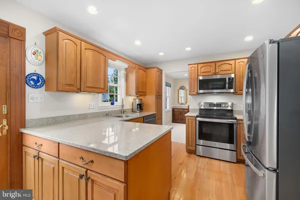 a kitchen with stainless steel appliances granite countertop a refrigerator sink and stove