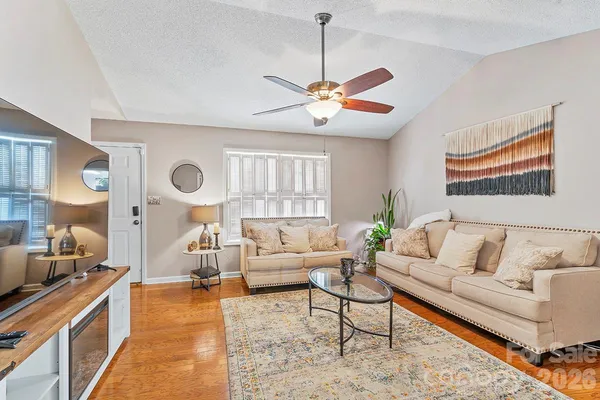 a living room with furniture kitchen view and a large window