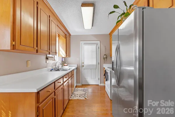 a kitchen with stainless steel appliances granite countertop a sink a refrigerator and a granite counter tops