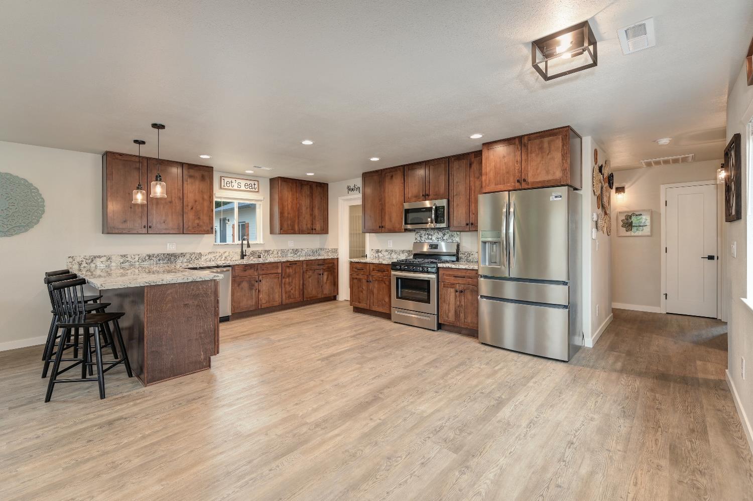 314 East Main Street Ione, CA 95640 - Photo 18 of 43 a kitchen with stainless steel appliances a refrigerator a stove a sink dishwasher and a refrigerator with wooden floor
