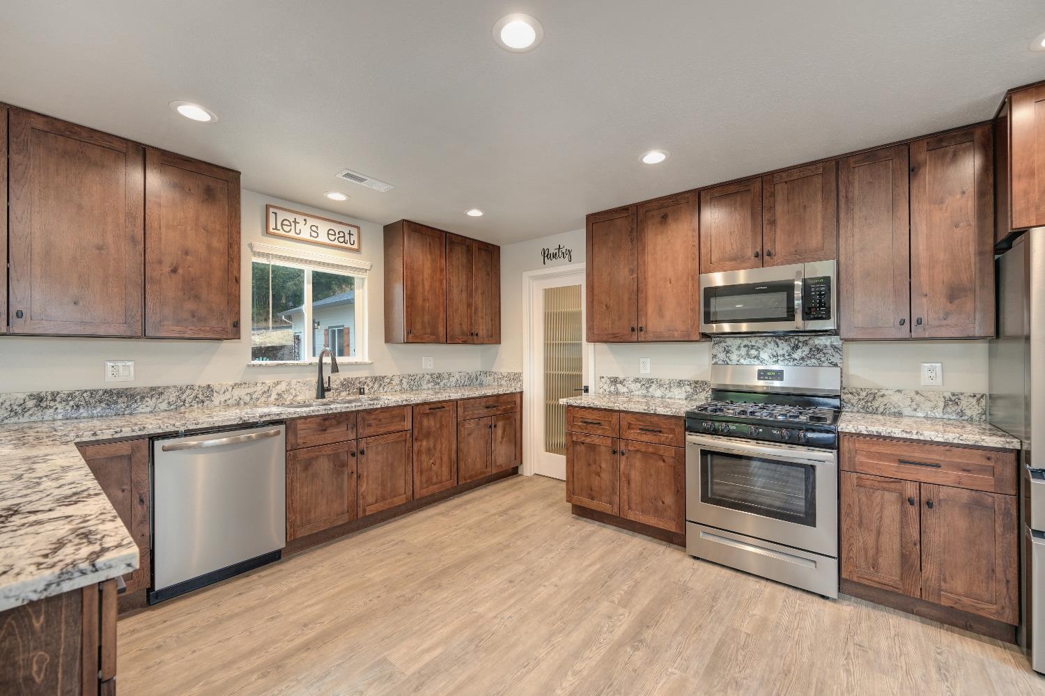 314 East Main Street Ione, CA 95640 - Photo 19 of 43 a large kitchen with granite countertop a stove top oven sink and cabinets