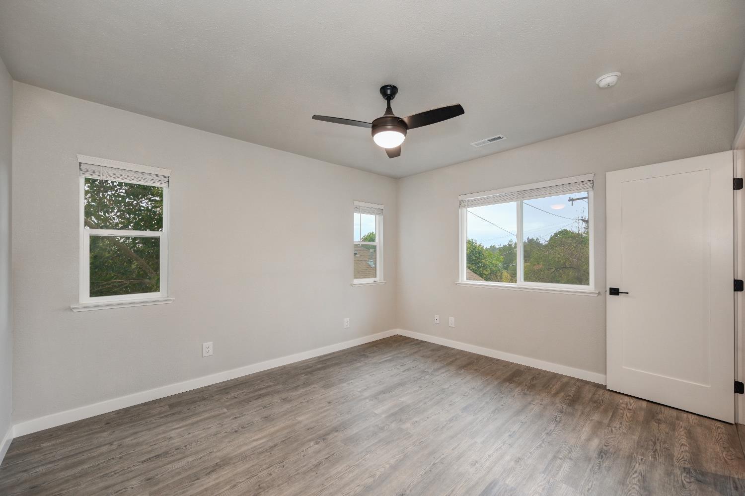 314 East Main Street Ione, CA 95640 - Photo 25 of 43 a view of empty room with wooden floor and fan