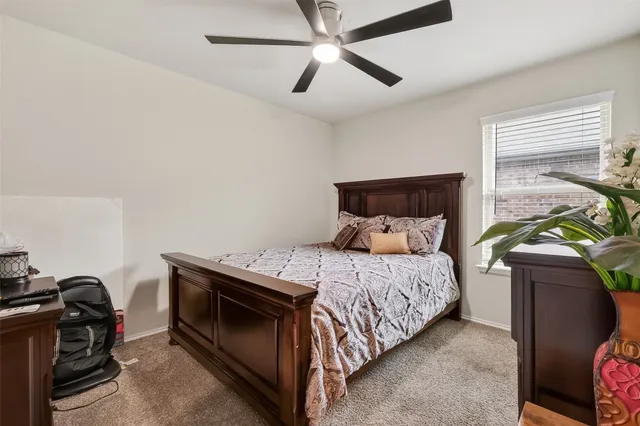 a bedroom with a bed and a ceiling fan