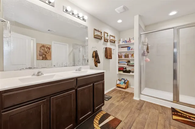 a bathroom with a double vanity sink a mirror and a shower
