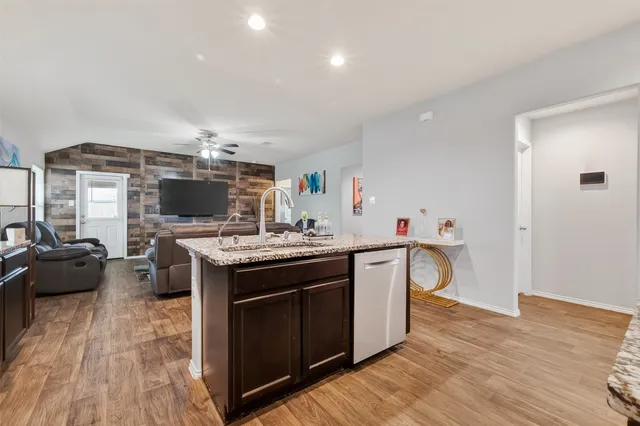 a kitchen with a sink cabinets and wooden floor