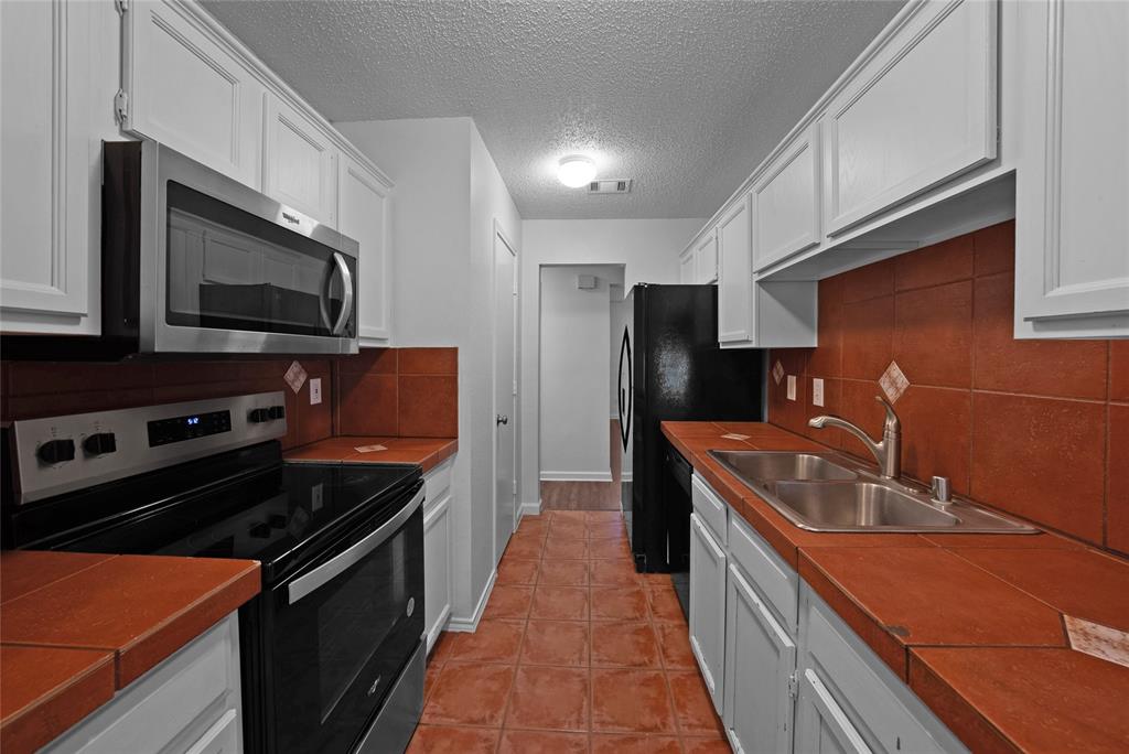 2910 Chisholm Trail Corinth, TX 76210 - Photo 11 of 30 a kitchen with stainless steel appliances granite countertop a stove a sink and a microwave
