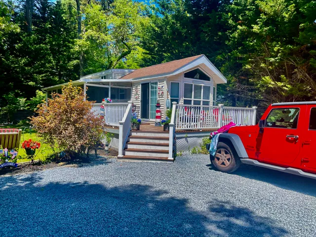 a front view of house with deck and yard