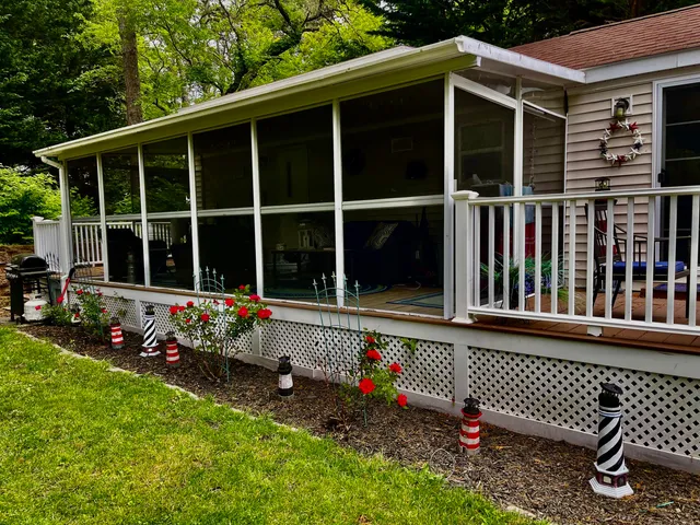 a view of a house with a large window and flower garden