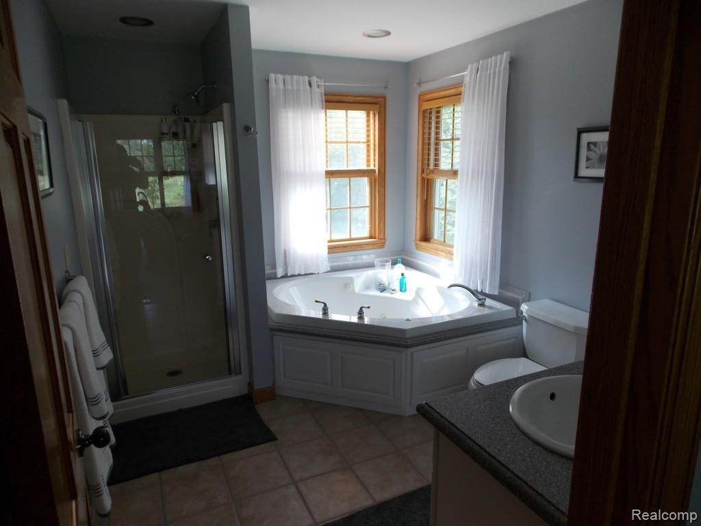 2974 Hannan Road Imlay City, MI 48444 - Photo 20 of 45 Large master bath with corner jetted top and separate shower. Dual vanity sink, also with corian counter tops.