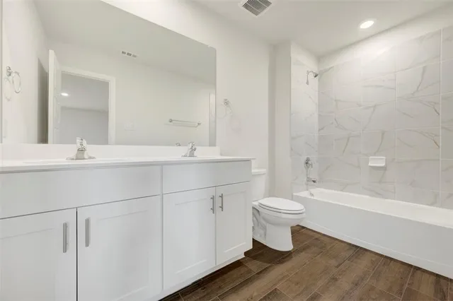 a bathroom with a double vanity sink toilet and shower