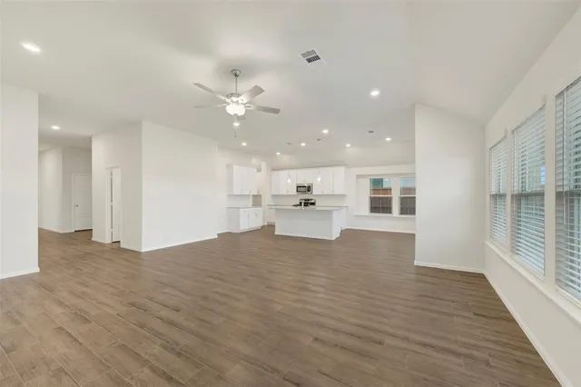 a view of kitchen with kitchen island white cabinets and refrigerator