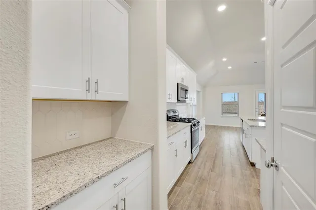 a view of a kitchen with kitchen island a sink wooden floor and floors
