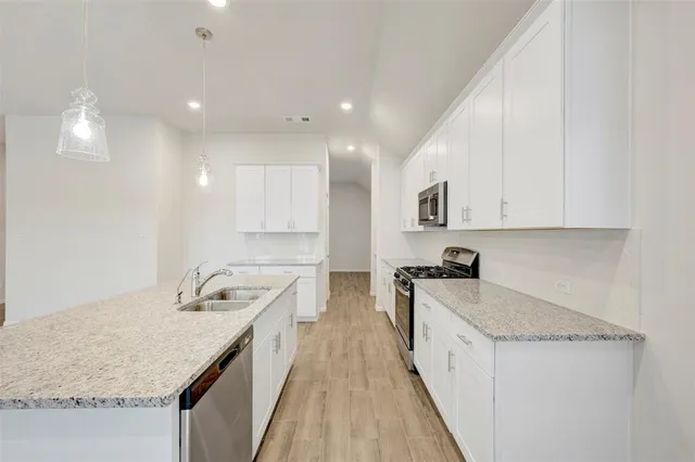 a kitchen with a sink stove and cabinets