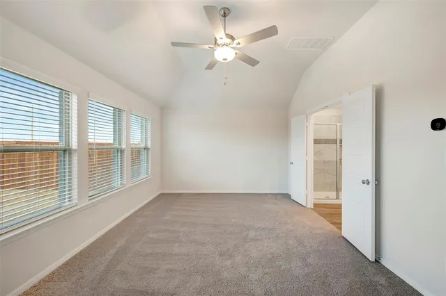 an empty room with chandelier fan and windows