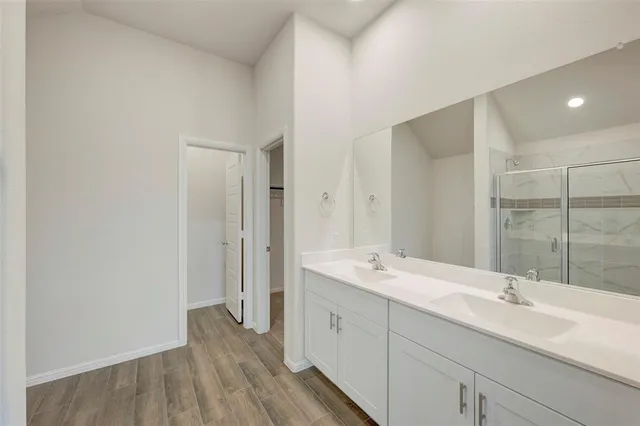 a spacious bathroom with a double vanity sink and mirror