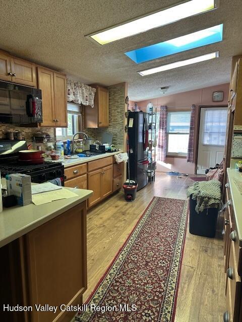 552 Travis Hill Road Rensselaerville, NY 12469 - Photo 5 of 11 a kitchen with stainless steel appliances granite countertop a stove top oven a sink dishwasher and cabinets with wooden floor