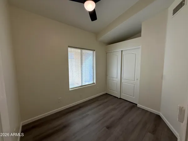a view of a room with wooden floor closet and windows