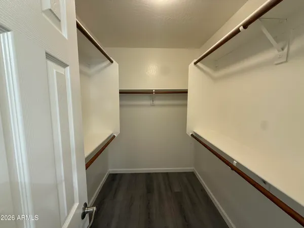 an empty room with wooden floor ceiling fan and windows