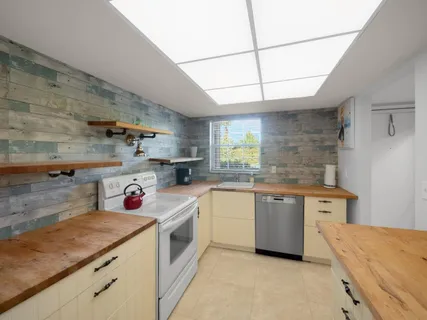 a kitchen with a sink dishwasher stove and white cabinets