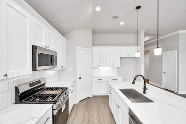a kitchen with a sink a stove and a microwave