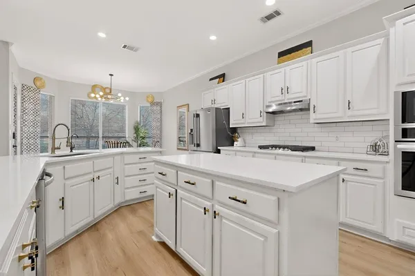 a kitchen with white cabinets and white appliances