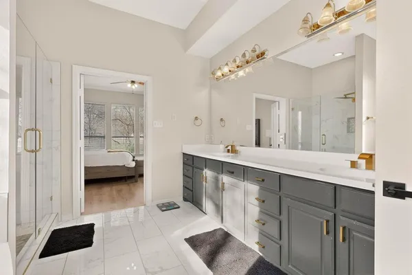 a spacious bathroom with a double vanity sink a mirror and a shower