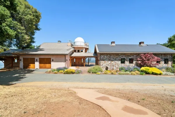 a front view of a house with a yard and potted plants