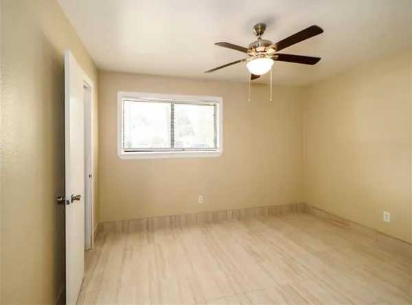 an empty room with closet and a chandelier fan